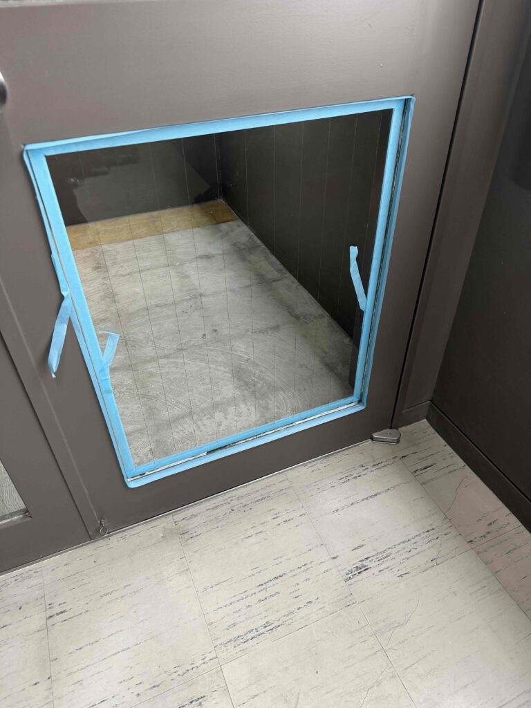 福岡市中央区大手門のホテルでコーキング施工のためマスキング養生を行っている透明縦ワイヤーガラス交換作業