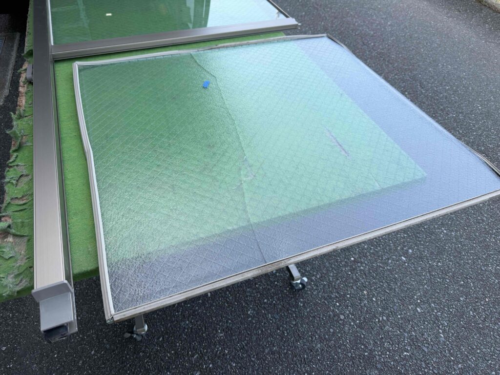 作業台に置いて既存の型網菱ガラスを撤去する様子